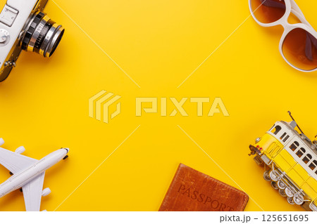 Travel-themed flat lay with toy airplane, camera, and sunglasses Travel-themed flat lay with toy airplane, camera, and sunglasses 125651695