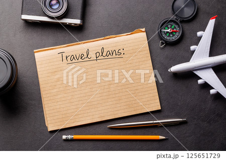 Creative flat lay of a travel-themed desk with notepad for plans Creative flat lay of a travel-themed desk with notepad for plans 125651729