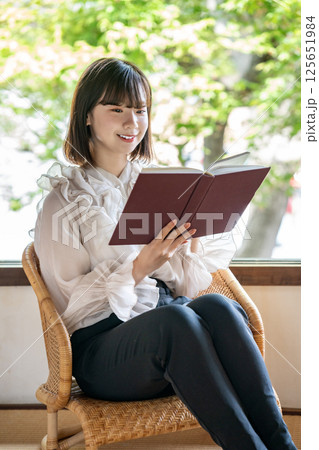 新緑が見える部屋で読書をする若い女性 125651984