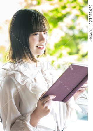新緑の中で読書をする若い女性 125652070