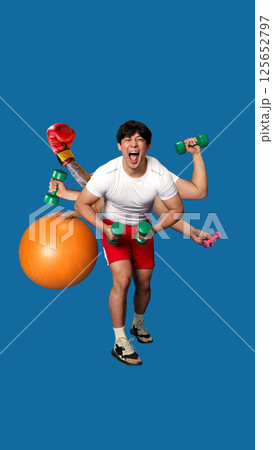 Excited young man with multiple hands holding dumbbells, boxing glove and fitness ball in action pose, screaming on blue background. 125652797
