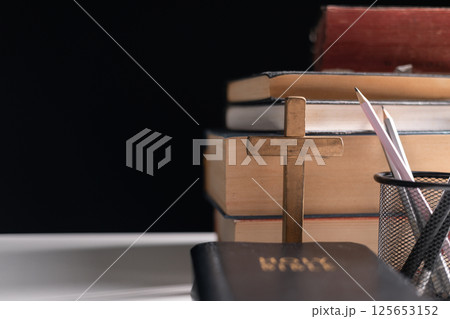 Old library, an open Bible lay on the table, its holy pages of scripture illuminated in the dark room. bible, holy, dark, old, open, library, pages, scripture, table, book, page. Old library, an open Bible lay on the table, its holy pages of scripture illuminated in the dark room. bible, holy, dark, old, open, library, pages, scripture, table, book, page. 125653152