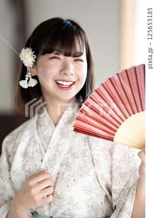扇子で涼む浴衣を着た若い女性 125653185