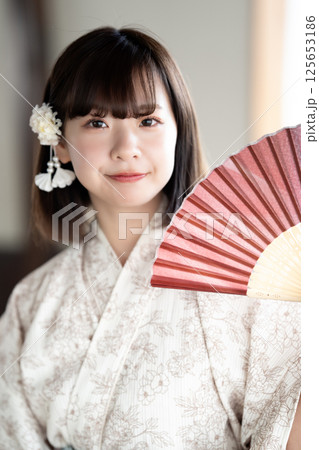 扇子で涼む浴衣を着た若い女性 125653186