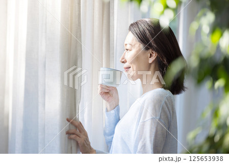 窓辺でコーヒーを飲む女性 125653938