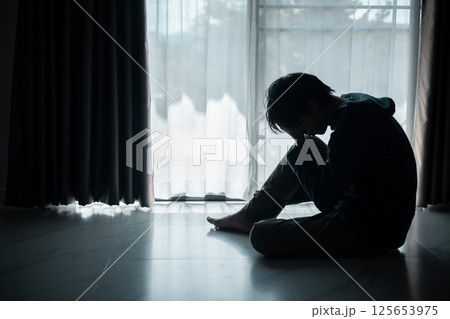 Silhouette of lost cast long shadow, embodying deep despair and hopelessness left him feeling perpetually stressed, sad, and unhappy. man sat alone, feeling weight of anxiety, stress, and depression. Silhouette of lost cast long shadow, embodying deep despair and hopelessness left him feeling perpetually stressed, sad, and unhappy. man sat alone, feeling weight of anxiety, stress, and depression. 125653975