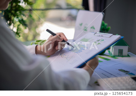 Analyzing green building performance metrics during business meeting. data analysis, green building, business meeting, sustainability, performance metrics, charts, graphs, real estate, eco-friendly. Analyzing green building performance metrics during business meeting. data analysis, green building, business meeting, sustainability, performance metrics, charts, graphs, real estate, eco-friendly. 125654173