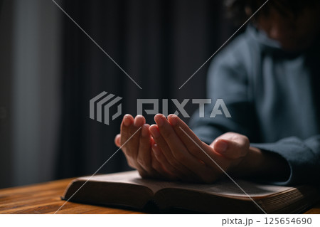 Person raised their hand in prayer at the church, embodying their Christian faith and belief in God, seeking hope and the holy presence of Christ through their devout religion. jesus christ, pray. Person raised their hand in prayer at the church, embodying their Christian faith and belief in God, seeking hope and the holy presence of Christ through their devout religion. jesus christ, pray. 125654690