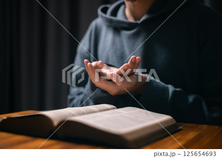 Person raised their hand in prayer at the church, embodying their Christian faith and belief in God, seeking hope and the holy presence of Christ through their devout religion. jesus christ, pray. Person raised their hand in prayer at the church, embodying their Christian faith and belief in God, seeking hope and the holy presence of Christ through their devout religion. jesus christ, pray. 125654693