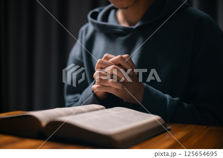 Person raised their hand in prayer at the church, embodying their Christian faith and belief in God, seeking hope and the holy presence of Christ through their devout religion. jesus christ, pray. Person raised their hand in prayer at the church, embodying their Christian faith and belief in God, seeking hope and the holy presence of Christ through their devout religion. jesus christ, pray. 125654695