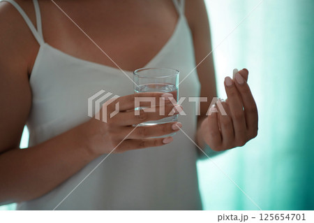 Sick female taking medicines, antidepressant, painkiller or antibiotic. Young lady drinking contraceptives. Pharmacy and healthcare concept Sick female taking medicines, antidepressant, painkiller or antibiotic. Young lady drinking contraceptives. Pharmacy and healthcare concept 125654701