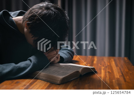 Person raised their hand in prayer at the church, embodying their Christian faith and belief in God, seeking hope and the holy presence of Christ through their devout religion. jesus christ, pray. 125654784
