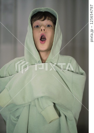 A young boy humorously posing with an open mouth and lively, animated expression. 125654797