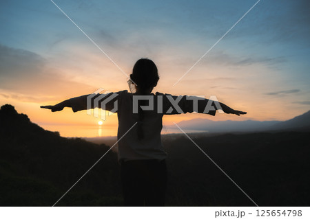 Girl embracing the sunset light with arms wide open in Costa del Sol, Marbella. Mental health Girl embracing the sunset light with arms wide open in Costa del Sol, Marbella. Mental health 125654798