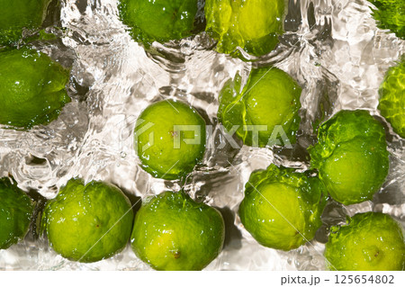 Fresh Whole Limes Floating in Water Top View 125654802