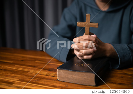 Person raised their hand in prayer at the church, embodying their Christian faith and belief in God, seeking hope and the holy presence of Christ through their devout religion. jesus christ, pray. 125654869
