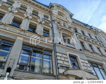 historical pink building with multiple floors, adorned with decorative features and air conditioning units on its windows. The combination of classic design and modern amenities highlights urban historical pink building with multiple floors, adorned with decorative features and air conditioning units on its windows. The combination of classic design and modern amenities highlights urban 125654905