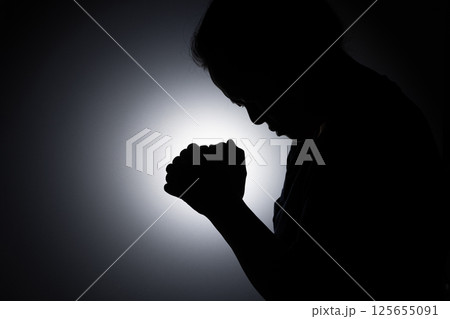 Profile silhouette of girl, young woman lowered her head and praying to God. Female catholic prayer worship to God wish a better life in home at dawn with believe faith. 125655091