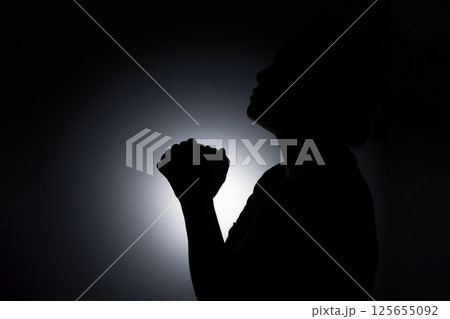 Profile silhouette of girl, young woman look up her head and praying to God. Female catholic prayer worship to God wish a better life in home at dawn with believe faith. 125655092