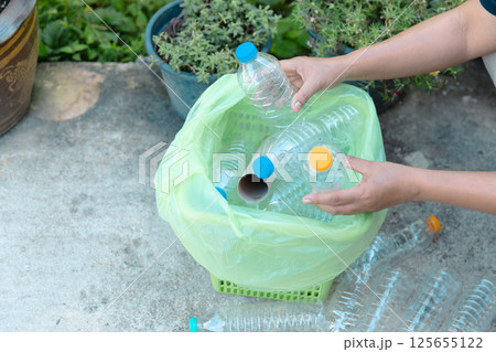 Plastic bottle waste for recycling, reuse concept. Volunteers store plastic bottles in cardboard boxes at a park. Disposal, recycling and waste management. Good conscience. 125655122