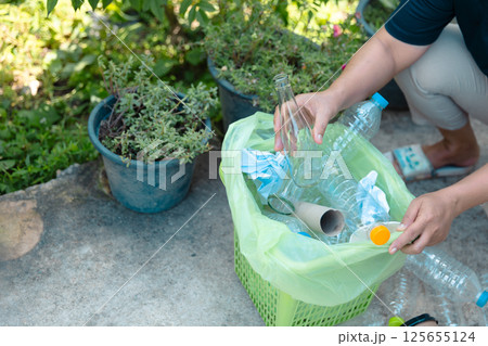 Plastic bottle waste for recycling, reuse concept. Volunteers store plastic bottles in cardboard boxes at a park. Disposal, recycling and waste management. Good conscience. 125655124