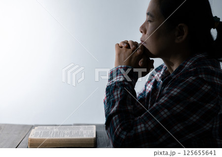 Christian life crisis prayer to god. Woman Pray for god blessing to wishing have a better life. woman hands praying to god with the bible. begging for forgiveness and believe in goodness. 125655641