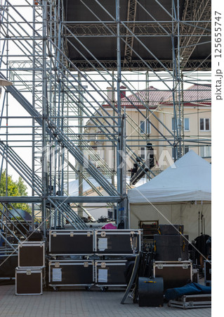 A large area is filled with stacked equipment cases and staging gear, being prepared for an upcoming event. A large area is filled with stacked equipment cases and staging gear, being prepared for an upcoming event. 125655747