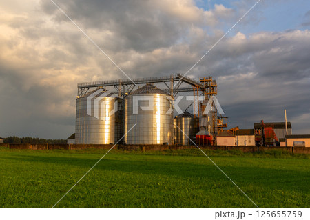 A captivating sunset over a grain dryer and hopper 125655759