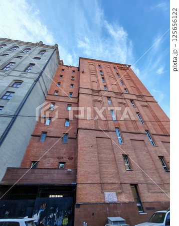 A historic red brick building with intricate patterns and a decorative balcony. The image highlights the durability of brick architecture and its aesthetic appeal, often seen in industrial or vintage A historic red brick building with intricate patterns and a decorative balcony. The image highlights the durability of brick architecture and its aesthetic appeal, often seen in industrial or vintage 125656122