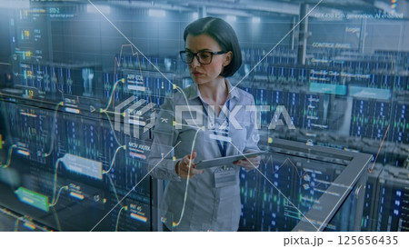 Big Data Center: Female Specialist Using Tablet Computer. Animated Charts of Internet Traffic on Servers Big Data Center: Female Specialist Using Tablet Computer. Animated Charts of Internet Traffic on Servers 125656435