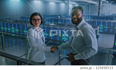 Big Data Center Multiethnic Specialists Talking, Shaking Hands, Looking at Camera Big Data Center Multiethnic Specialists Talking, Shaking Hands, Looking at Camera 125656513