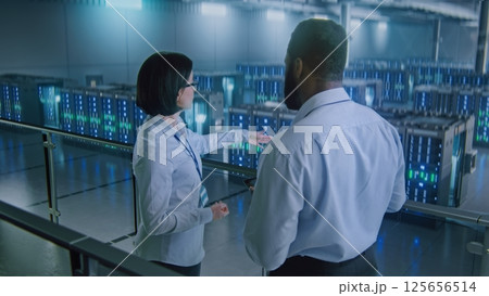 Big Data Center Multiethnic Specialists Talking, Shaking Hands, Looking at Camera Big Data Center Multiethnic Specialists Talking, Shaking Hands, Looking at Camera 125656514