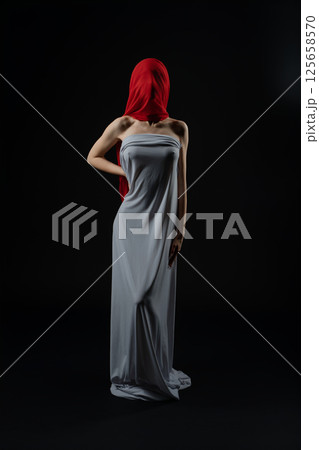Model poses in a dramatic fashion casting with a striking red headscarf Model poses in a dramatic fashion casting with a striking red headscarf 125658570