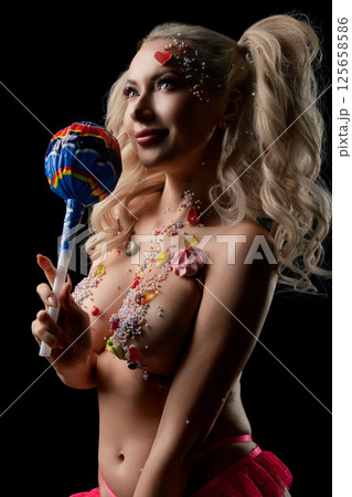 Woman showcasing body art with vibrant colors and candy-themed elements Woman showcasing body art with vibrant colors and candy-themed elements 125658586