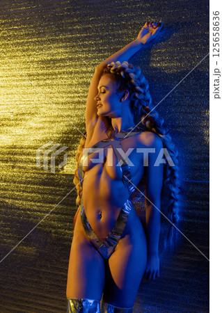 Expressive body art featuring a woman adorned in silver tape and lingerie Expressive body art featuring a woman adorned in silver tape and lingerie 125658636