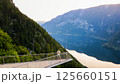 Young man standing on the viewing platform with drone controller view of Hallstatt lake, mountains 125660151