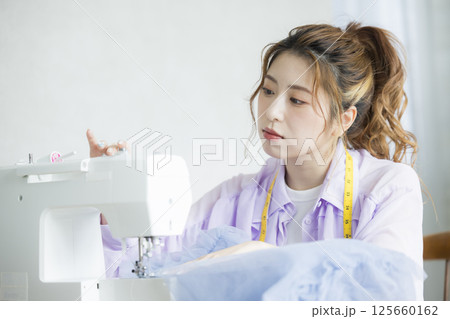 ミシンで裁縫する若い女性 125660162