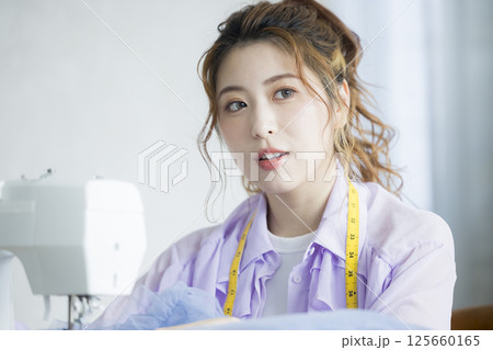 ミシンで裁縫する若い女性 125660165