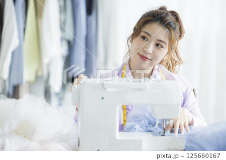 ミシンで裁縫する若い女性 125660167