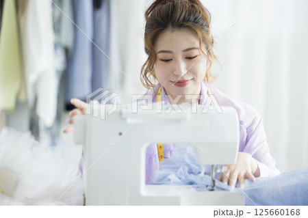 ミシンで裁縫する若い女性 125660168