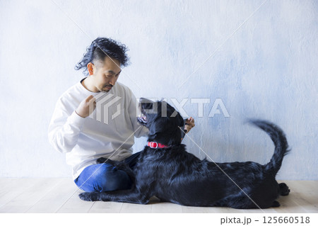 愛犬とくつろぐ男性　 125660518