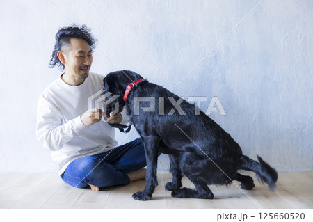 愛犬とくつろぐ男性　 125660520