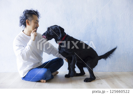 愛犬とくつろぐ男性　 125660522