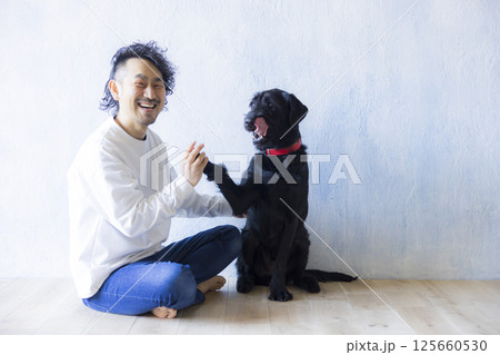 愛犬とくつろぐ男性　 125660530