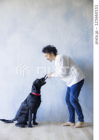愛犬とくつろぐ男性　 125660531