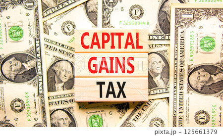 Capital gains tax symbol. Concept words Capital gains tax on beautiful wooden blocks. Dollar bills. Beautiful background from dollar bills. Business and capital gains tax concept. Copy space. Capital gains tax symbol. Concept words Capital gains tax on beautiful wooden blocks. Dollar bills. Beautiful background from dollar bills. Business and capital gains tax concept. Copy space. 125661379