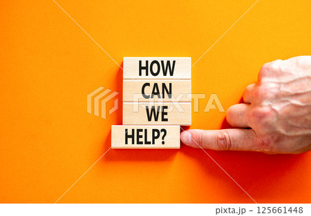 How can we help symbol. Concept words How can we help on beautiful wooden blocks. Beautiful orange table orange background. Businessman hand. Business and how can we help concept. Copy space. 125661448