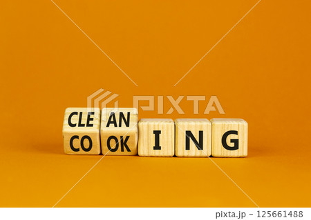 Cleaning or cooking symbol. Turned wooden cubes and changed the word cooking to cleaning. Beautiful orange background. Business, cleaning or cooking concept. Copy space. Cleaning or cooking symbol. Turned wooden cubes and changed the word cooking to cleaning. Beautiful orange background. Business, cleaning or cooking concept. Copy space. 125661488