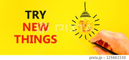 Try new things symbol. Concept words Try new things on beautiful yellow paper. Beautiful yellow background. Businessman hand, pen. Business motivational lifestyle try new things concept. Copy space. 125661530