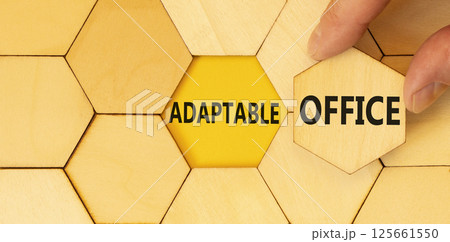 Adaptable office symbol. Concept words Adaptable office on beautiful wooden puzzles. Beautiful yellow background. Businessman hand. Business Adaptable office concept. Copy space. Adaptable office symbol. Concept words Adaptable office on beautiful wooden puzzles. Beautiful yellow background. Businessman hand. Business Adaptable office concept. Copy space. 125661550